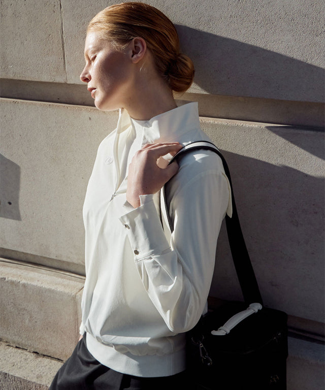 Anell Golf Classic Slim Knit Top in Ivory featuring a turtleneck and diagonal design details.