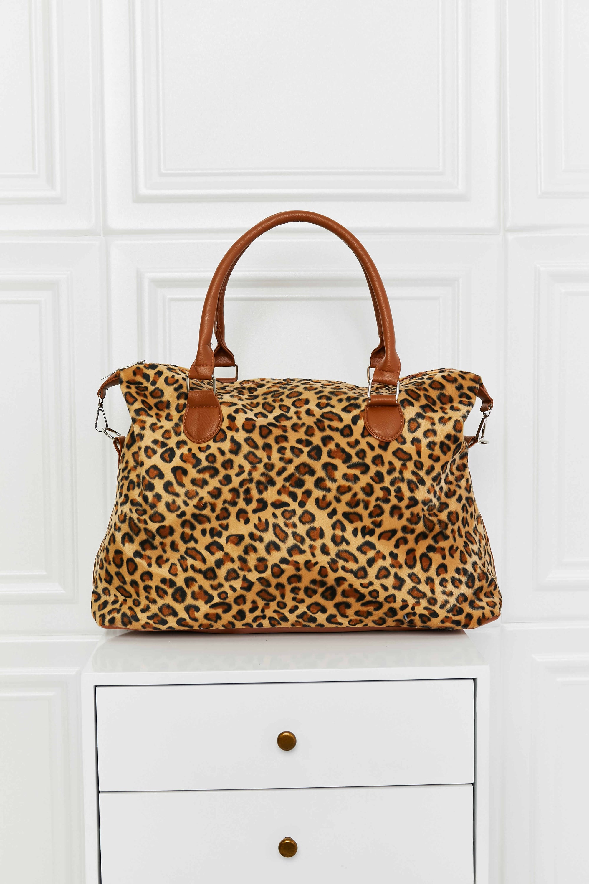 Animal Print Brushed Weekender Bag featuring a leopard pattern, medium size, and top handle for easy carrying.