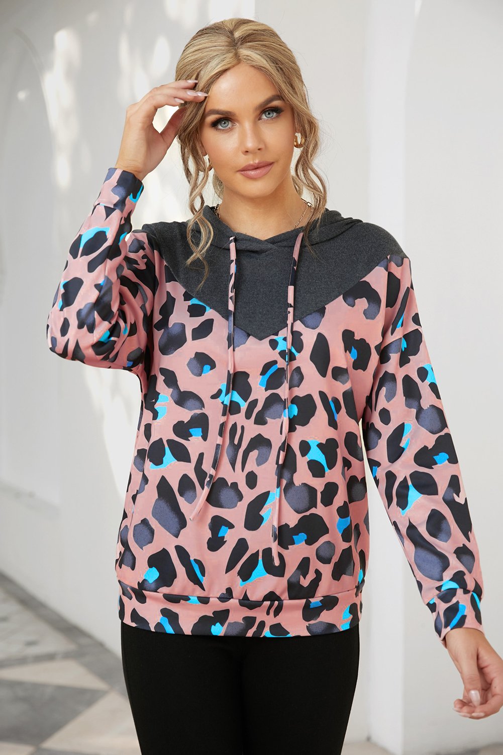 A stylish Animal Spotted Pullover Hoodie featuring a trendy animal print in pastel hues with a charcoal gray block at the neckline.