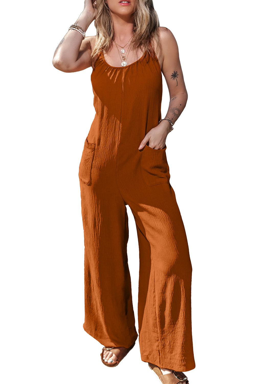 Apricot spaghetti straps jumpsuit with waist tie and pockets, featuring a wide leg design.