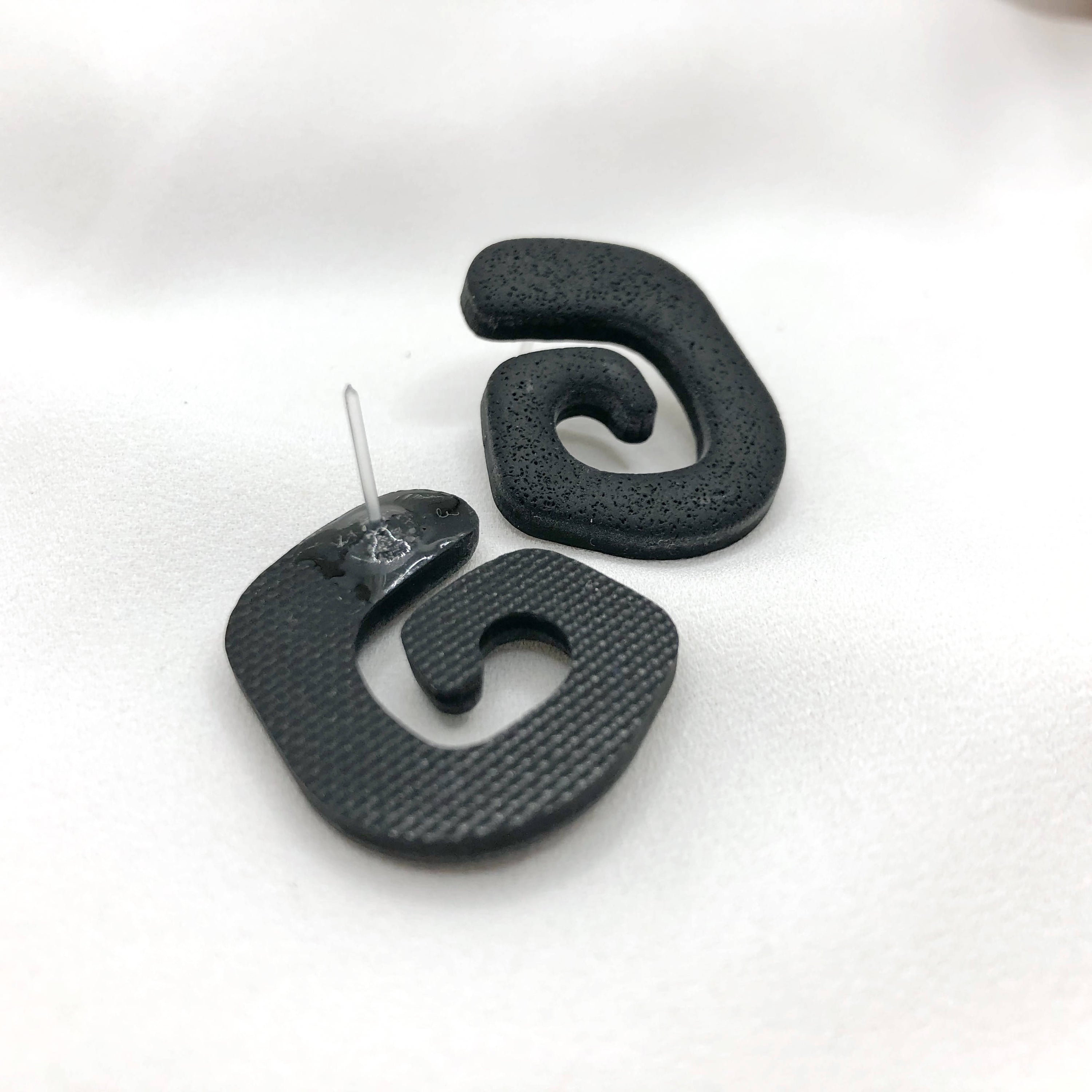 Artisan made black polymer clay earrings, lightweight and nickel-free, showcasing unique handmade design.