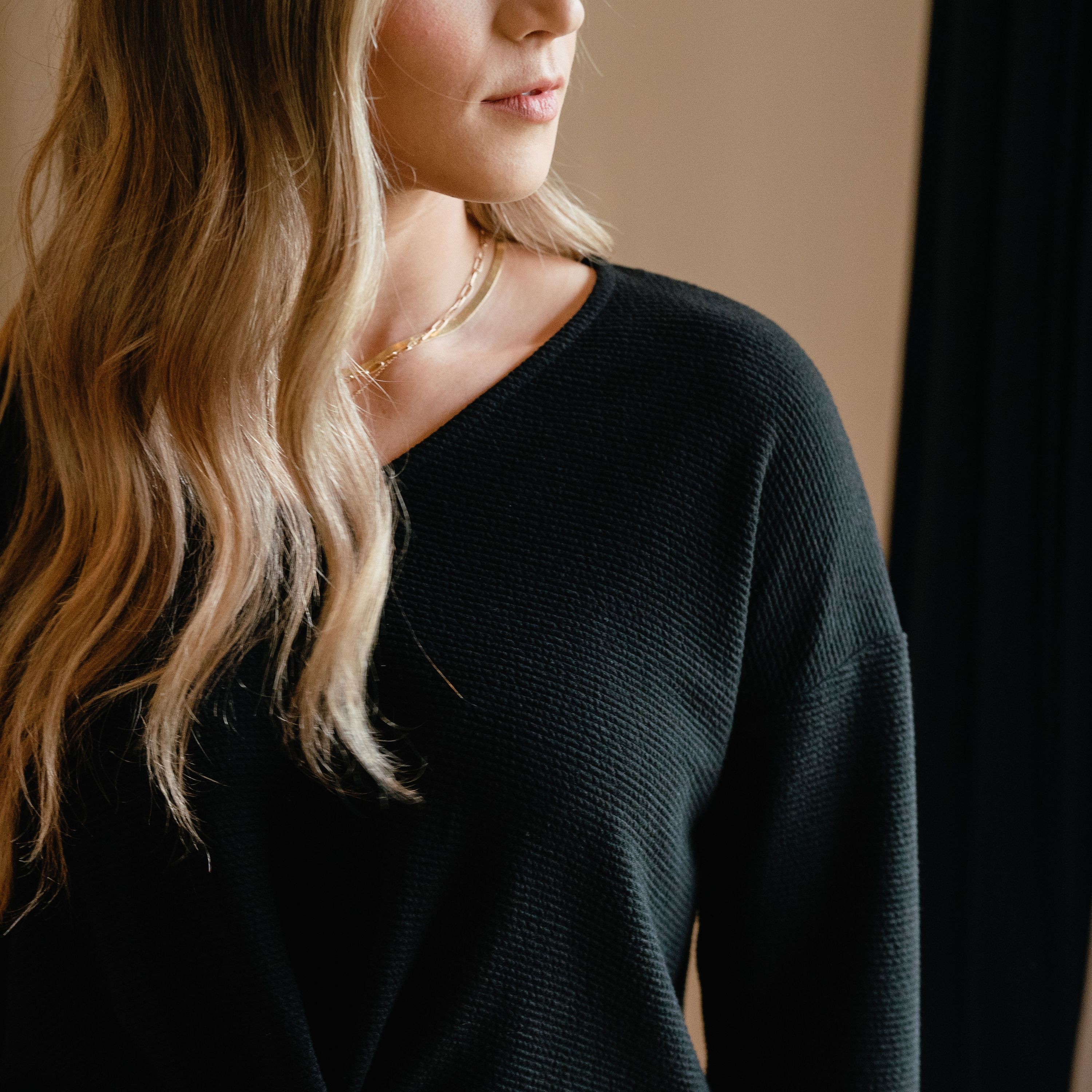 Aspen Textured Top in Black featuring a stylish crossover design and textured pattern, perfect for versatile outfits.