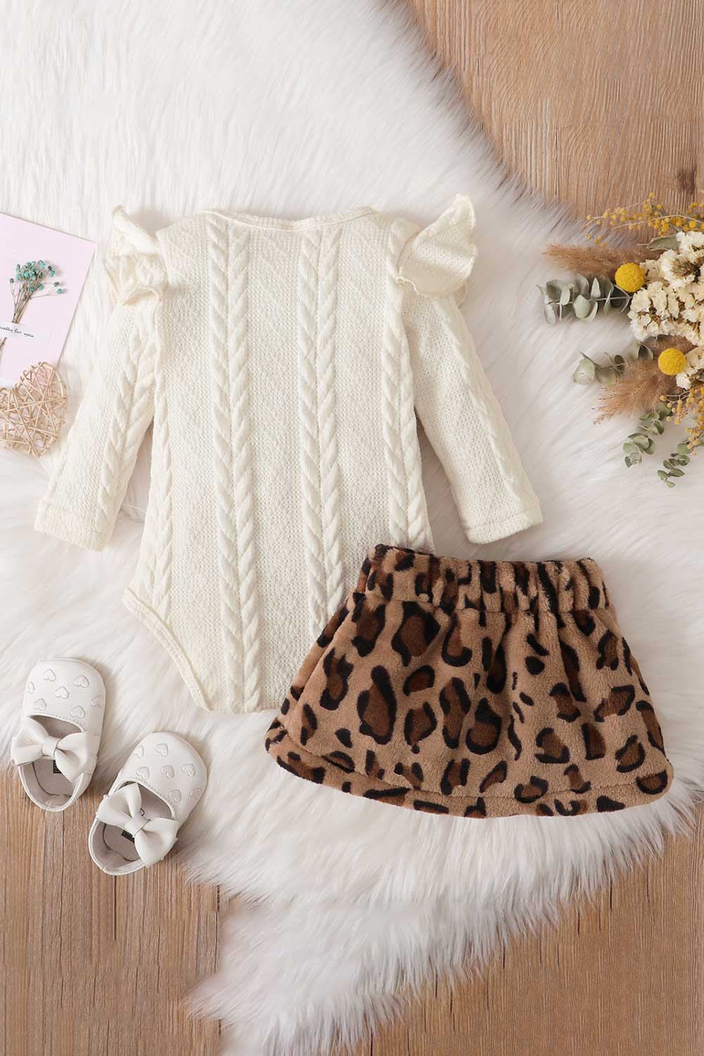 Baby girl wearing a letter graphic sweater and leopard print skirt, showcasing a stylish and comfortable outfit for infants.