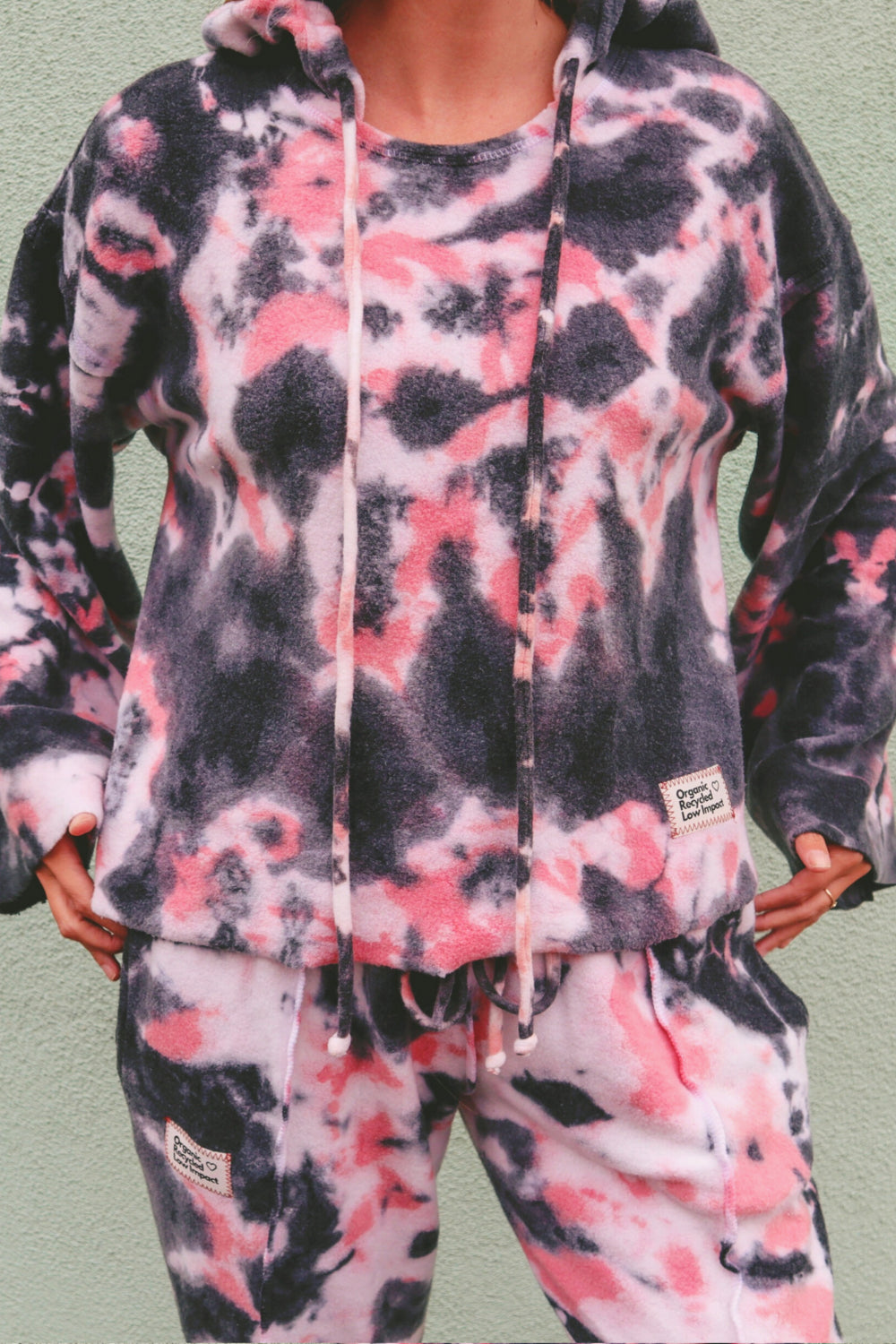 Baja Hoodie Tie-Dye in pink and black, showcasing its boxy silhouette and lightweight fabric.