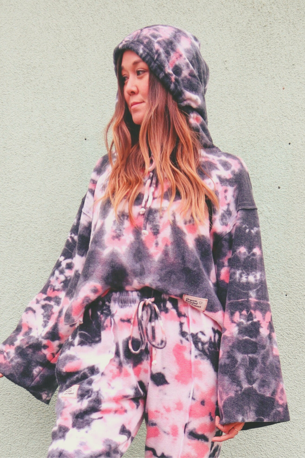 Baja Hoodie Tie-Dye in pink and black, showcasing its boxy silhouette and lightweight fabric.