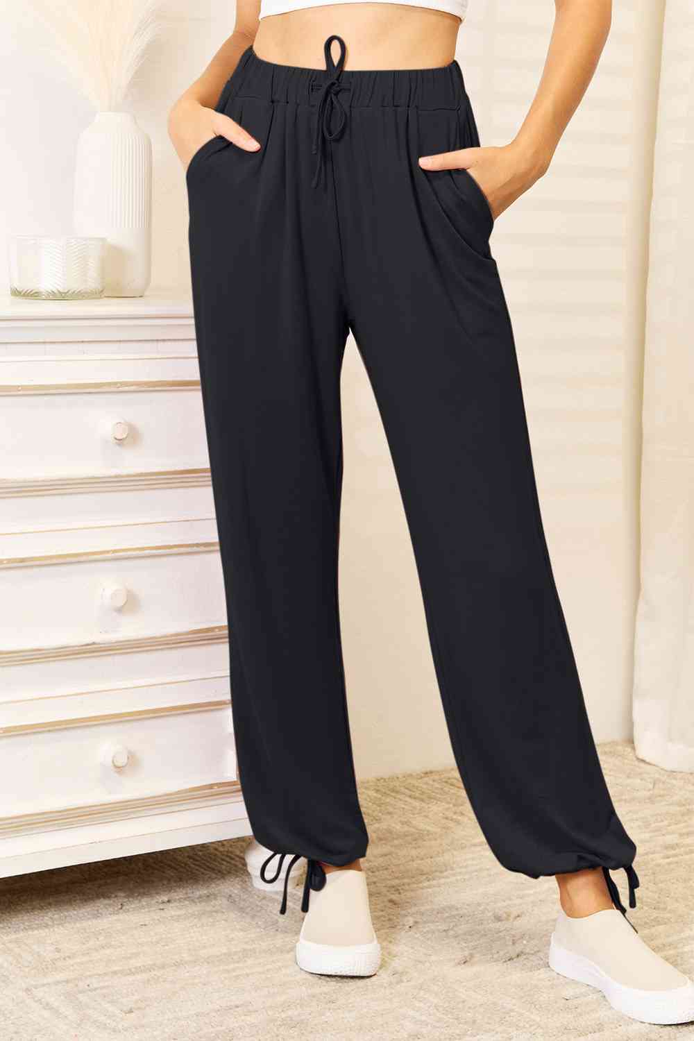 Basic Bae Full Size Soft Rayon Drawstring Waist Pants in black with pockets, showcasing a comfortable fit and stylish design.