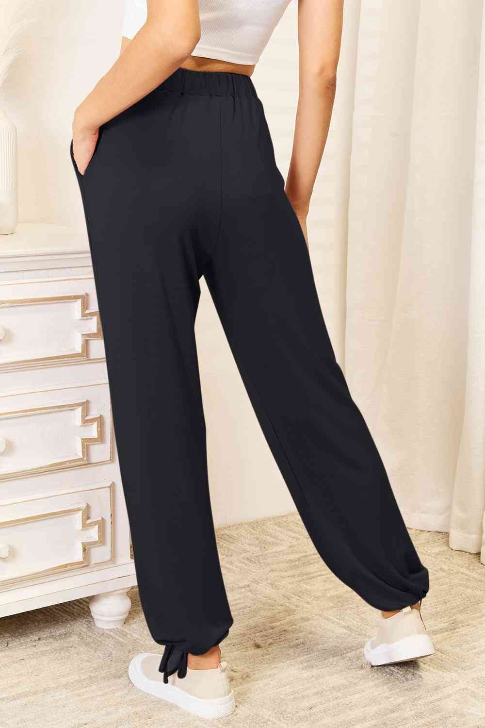 Basic Bae Full Size Soft Rayon Drawstring Waist Pants in black with pockets, showcasing a comfortable fit and stylish design.