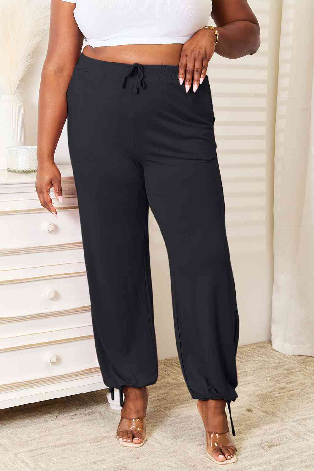 Basic Bae Full Size Soft Rayon Drawstring Waist Pants in black with pockets, showcasing a comfortable fit and stylish design.