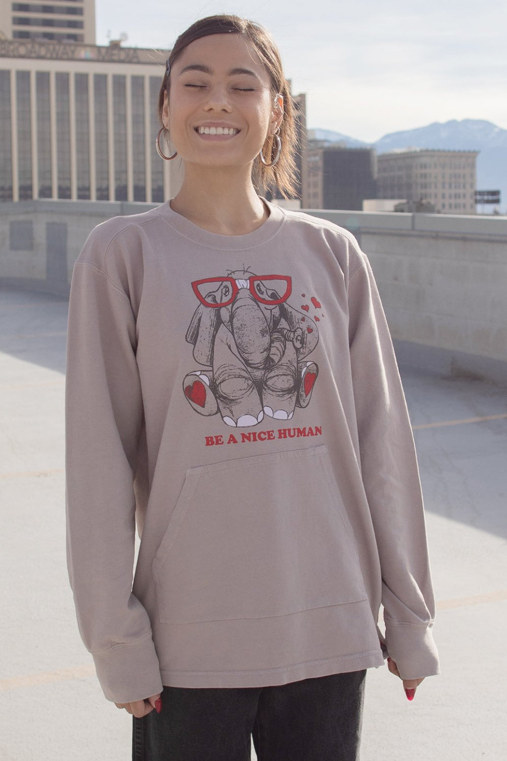 Mistic gray pullover featuring 'Be A Nice Human' graphic, front pockets, and cuffed sleeves.