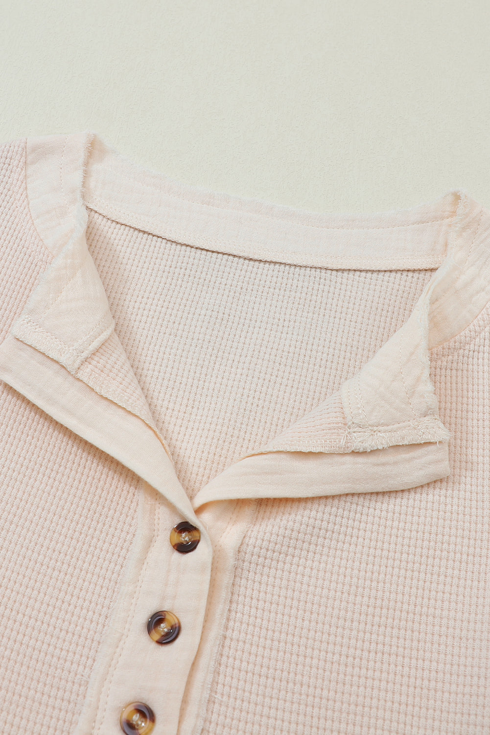 Beige Waffle Knit Textured Henley Top displayed on a mannequin, showcasing its elegant design and soft texture.