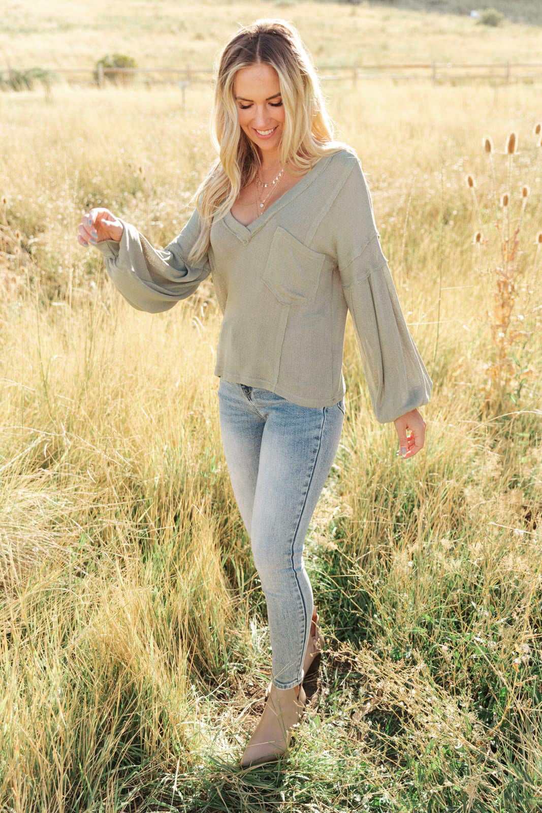 Bellissimo Draped V-Neck Sweater in Olive, featuring a deep V-neckline and raw stitching details, perfect for layering.