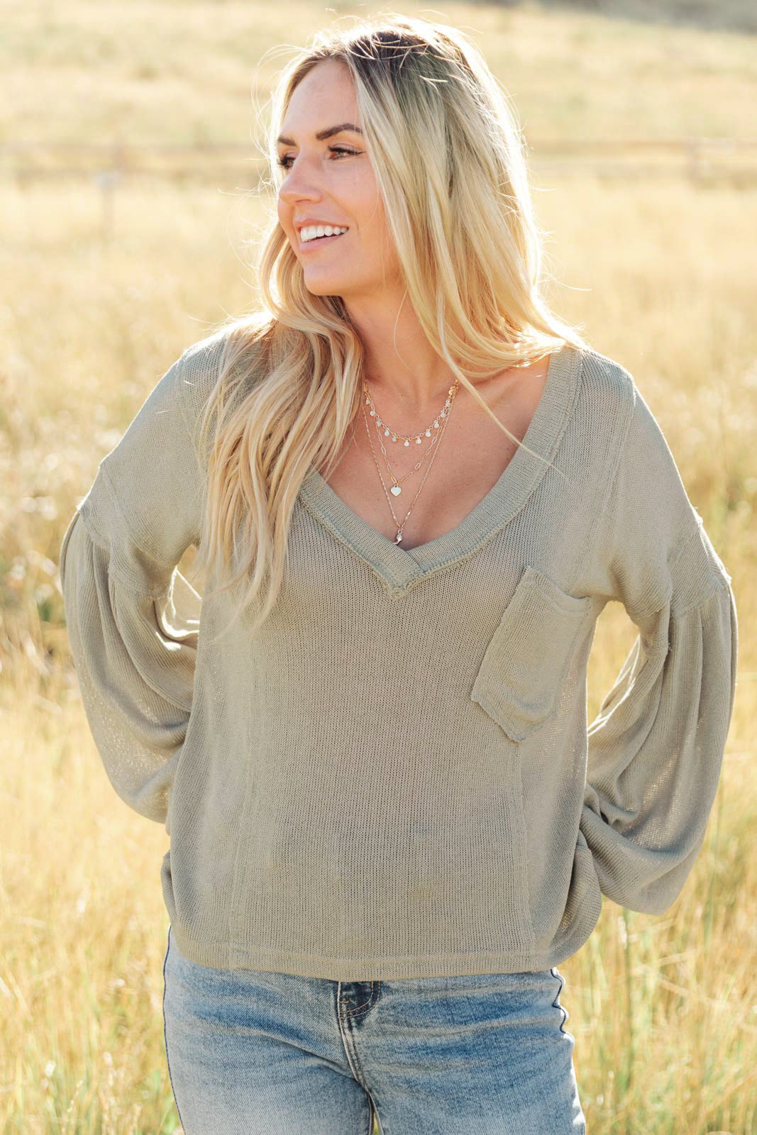 Bellissimo Draped V-Neck Sweater in Olive, featuring a deep V-neckline and raw stitching details, perfect for layering.