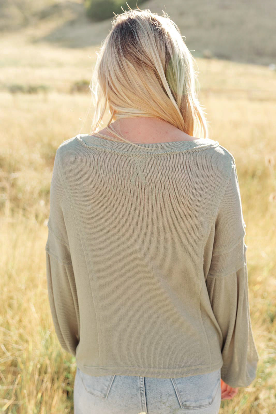 Bellissimo Draped V-Neck Sweater in Olive, featuring a deep V-neckline and raw stitching details, perfect for layering.