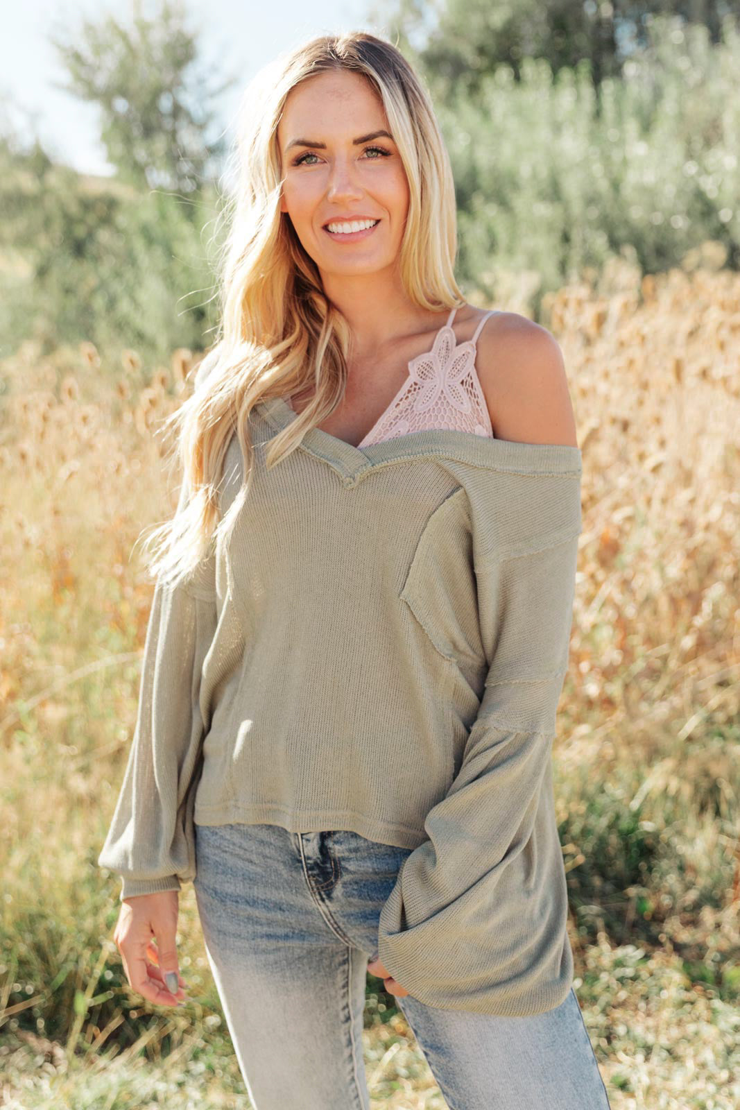 Bellissimo Draped V-Neck Sweater in Olive, featuring a deep V-neckline and raw stitching details, perfect for layering.