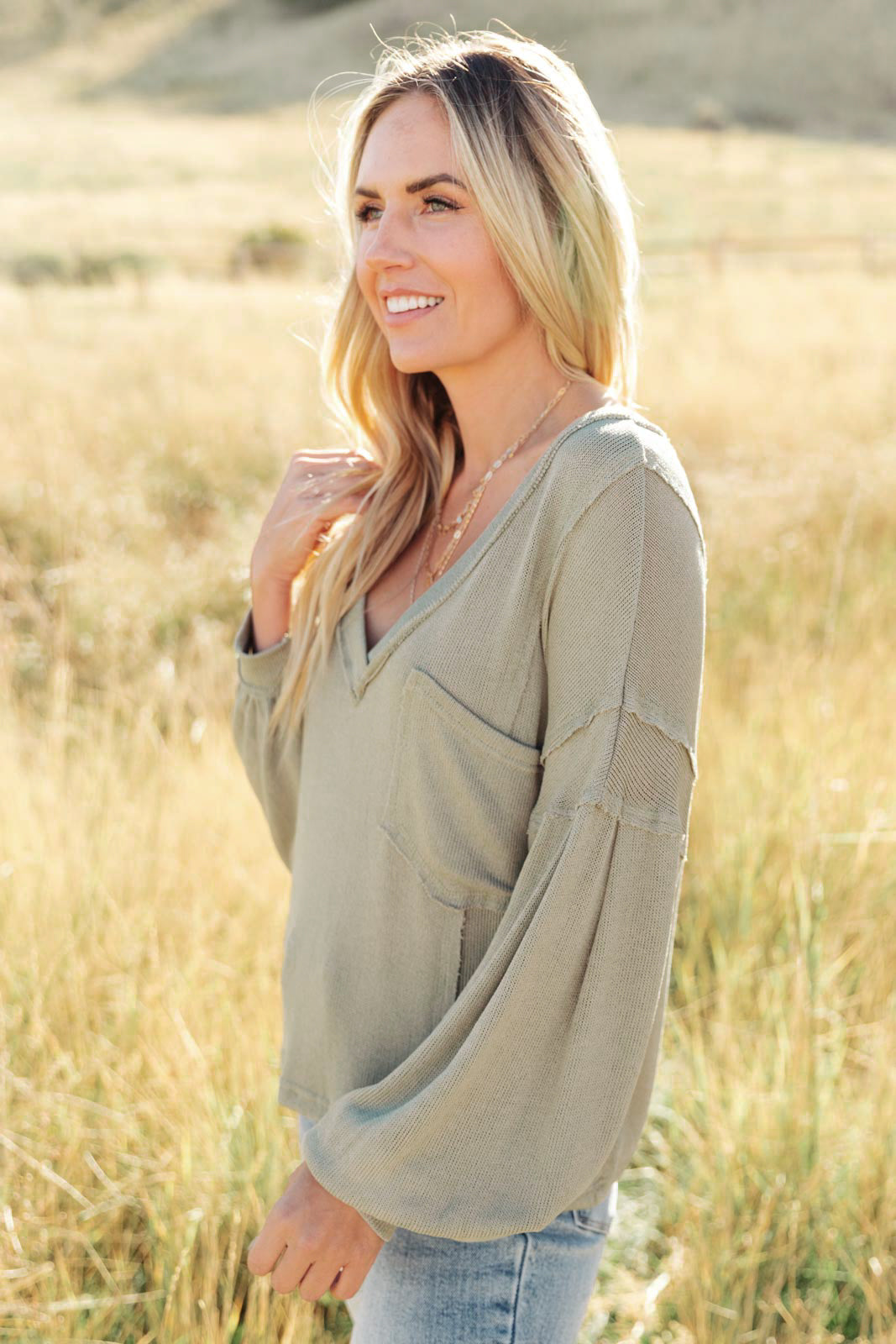 Bellissimo Draped V-Neck Sweater in Olive, featuring a deep V-neckline and raw stitching details, perfect for layering.