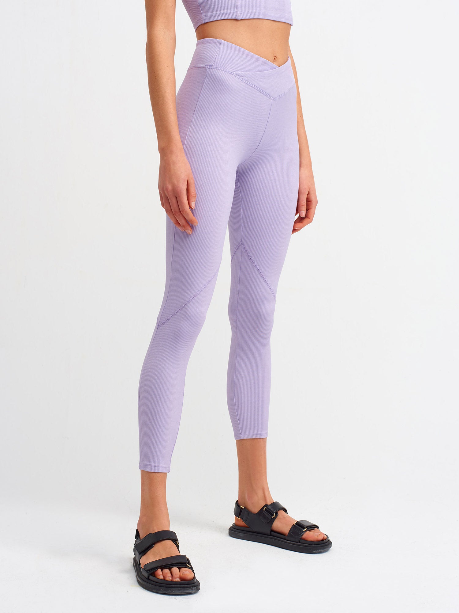 A pair of stylish black belt detailed leggings displayed on a white background, showcasing the unique belt design and soft fabric texture.