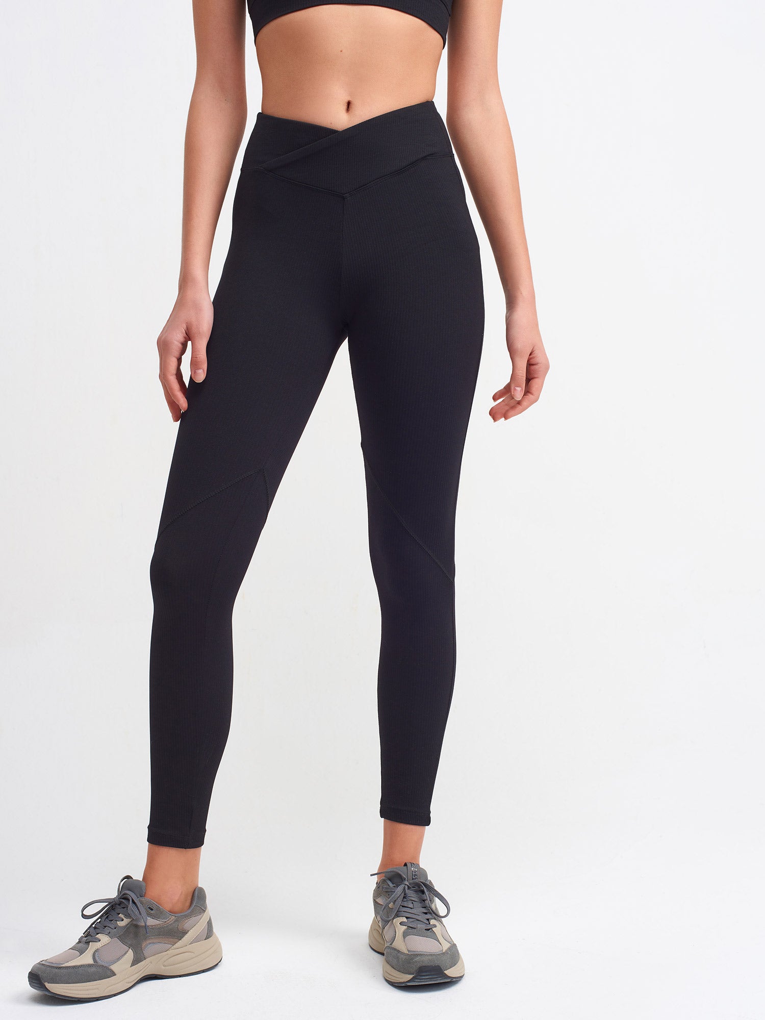 A pair of stylish black belt detailed leggings displayed on a white background, showcasing the unique belt design and soft fabric texture.