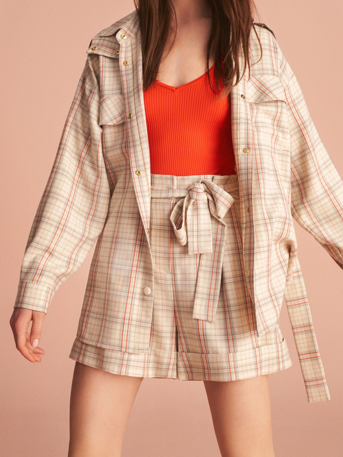 Belted plaid shorts featuring a wide fit, side pockets, and a tied self belt in vibrant colors.