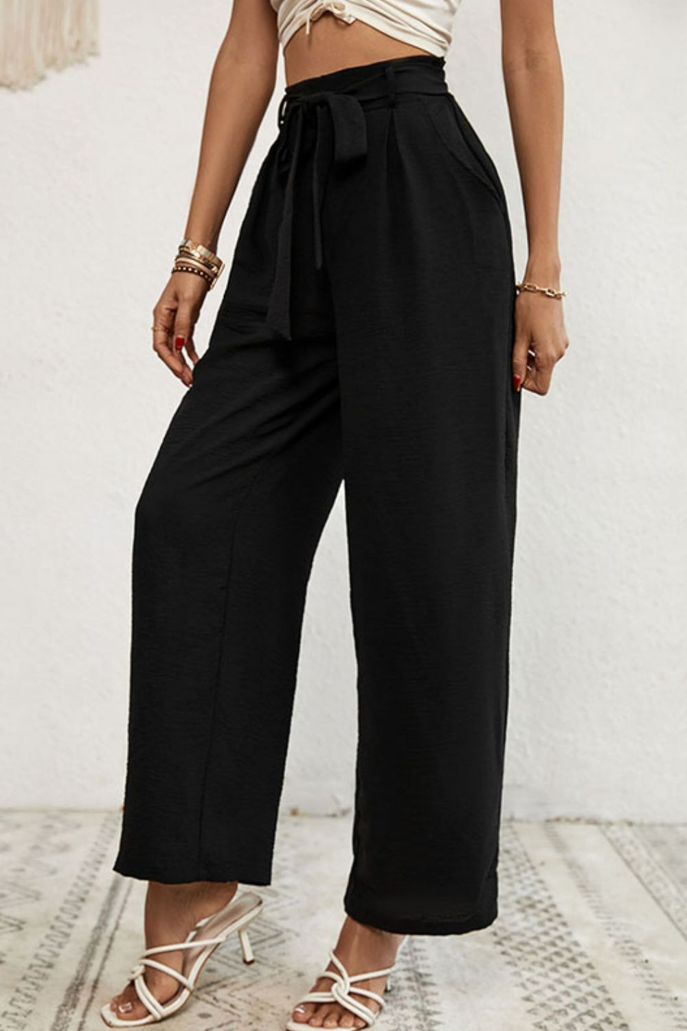 Belted pleated waist wide leg pants in a solid color, showcasing a minimalist design with a stylish belt.