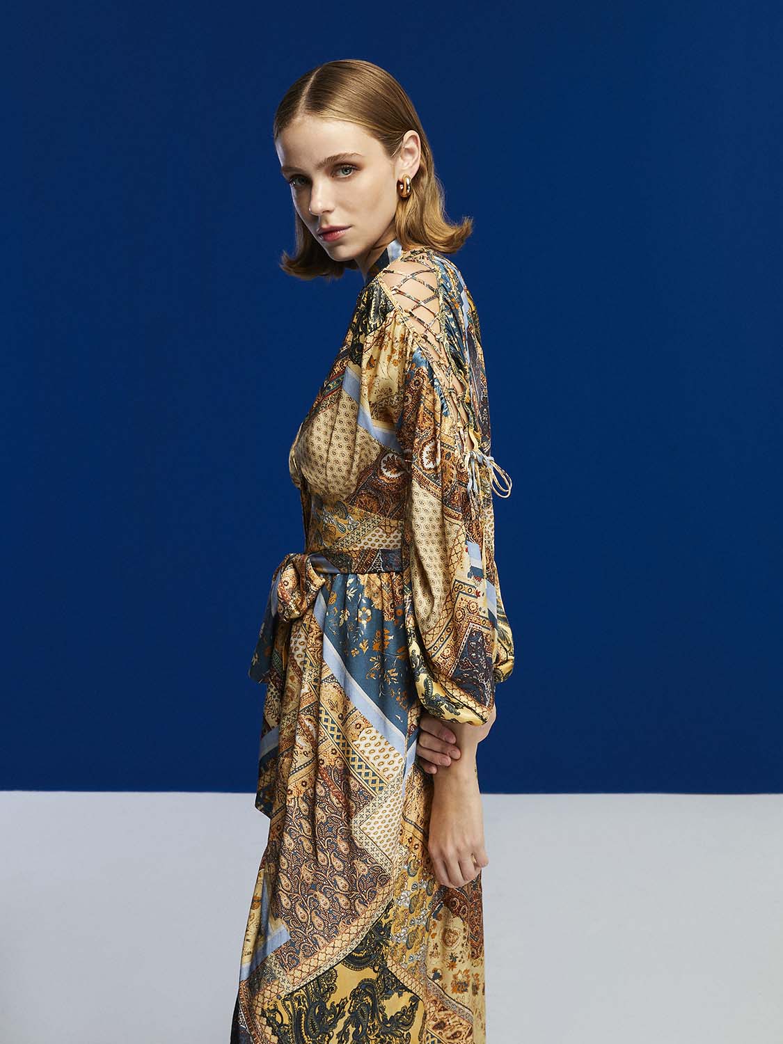 A stylish long-sleeved belted print dress in toasty brown with a Mandarin collar and side slits, perfect for winter wear.