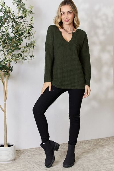 BiBi Notched Popcorn Waffle Long Sleeve Top in a cozy popcorn knit with a front pocket, showcasing its relaxed style and comfortable fit.