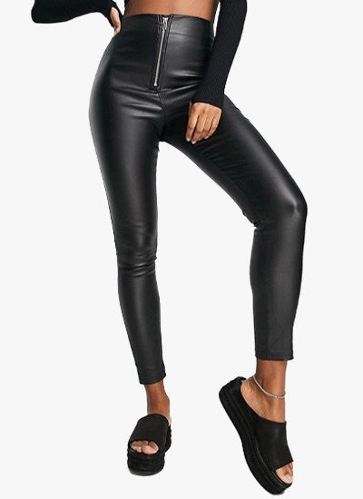 Black coated skinny trousers with exposed zip and side split hem, showcasing a sleek faux leather finish.