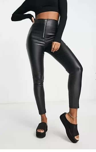 Black coated skinny trousers with exposed zip and side split hem, showcasing a sleek faux leather finish.