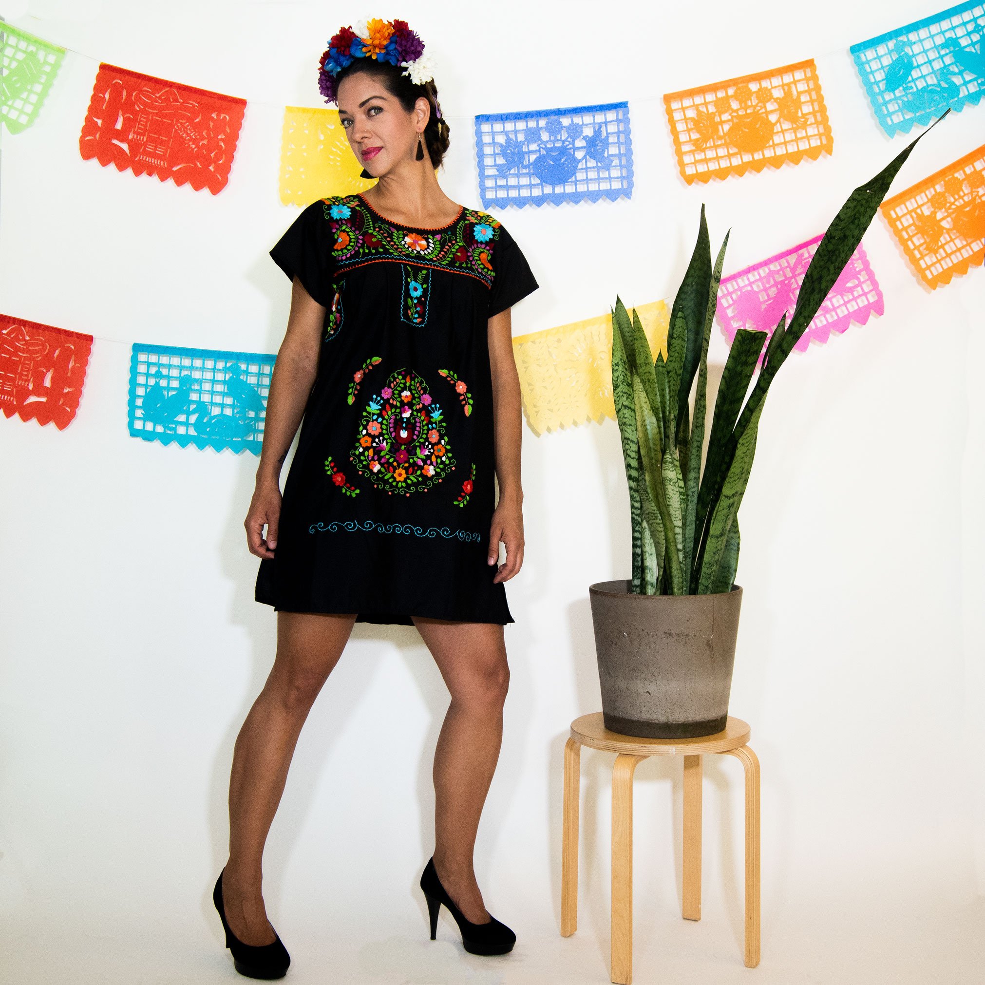 A beautiful Black Mexican Dress adorned with vibrant multicolored flowers, showcasing intricate hand embroidery.