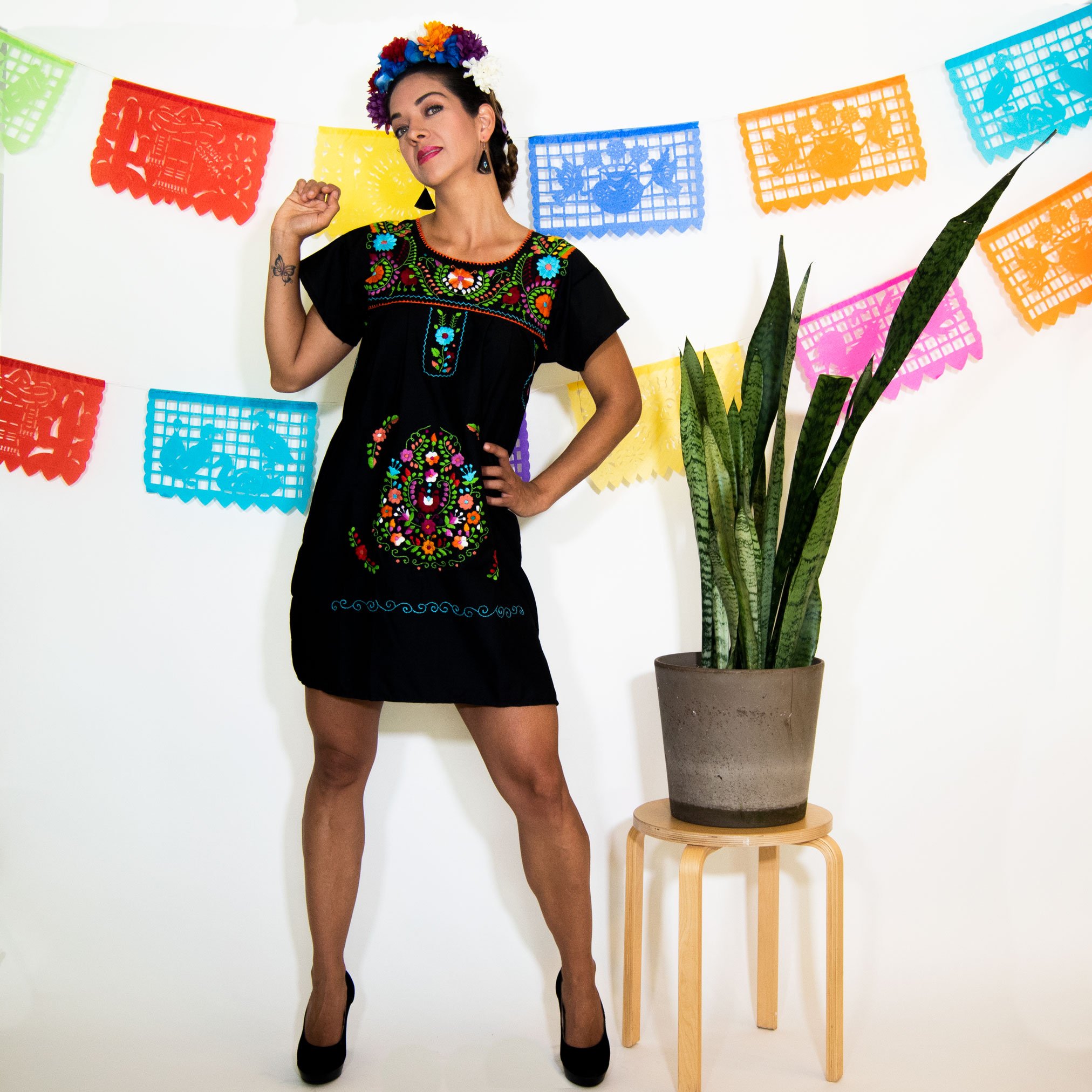 A beautiful Black Mexican Dress adorned with vibrant multicolored flowers, showcasing intricate hand embroidery.