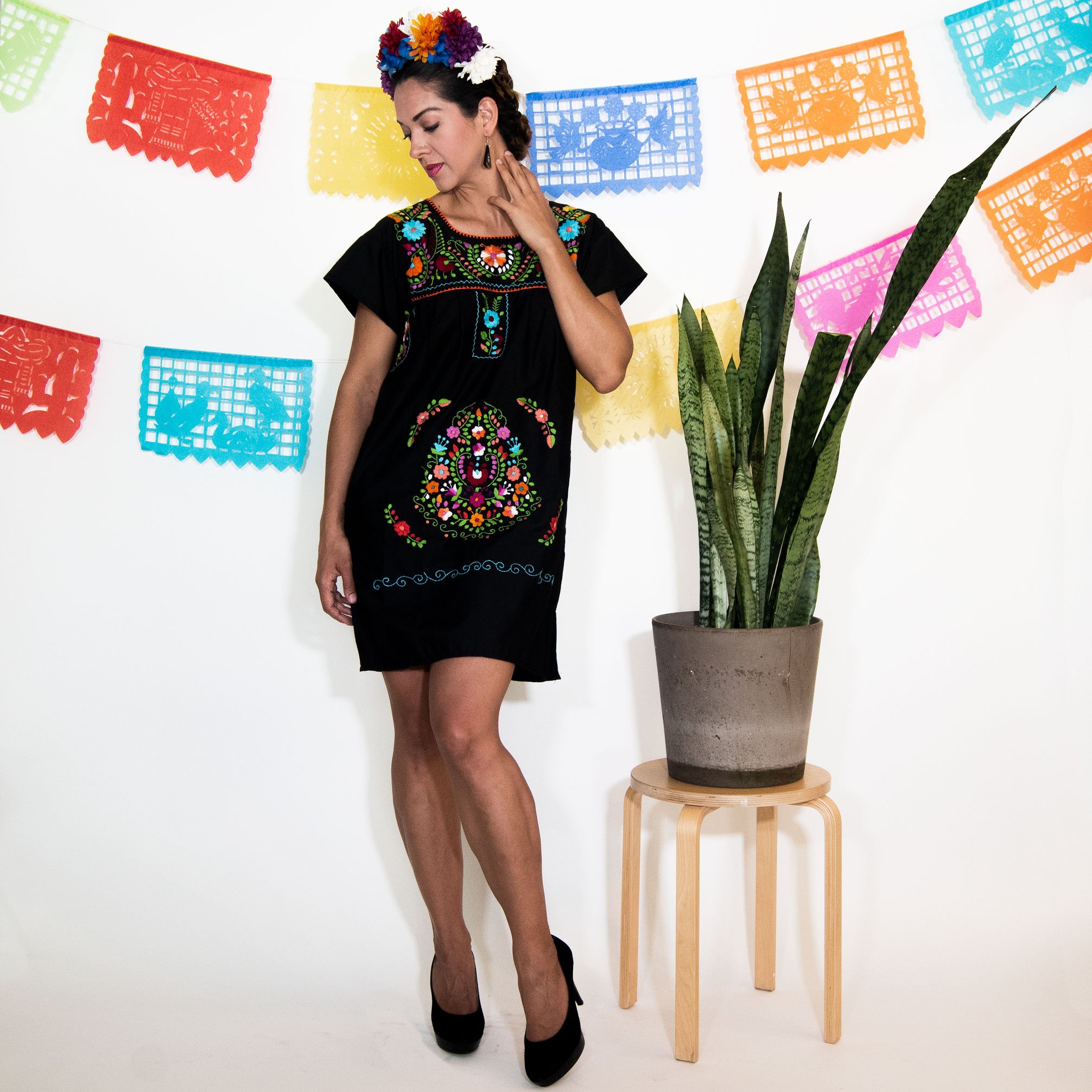 A beautiful Black Mexican Dress adorned with vibrant multicolored flowers, showcasing intricate hand embroidery.