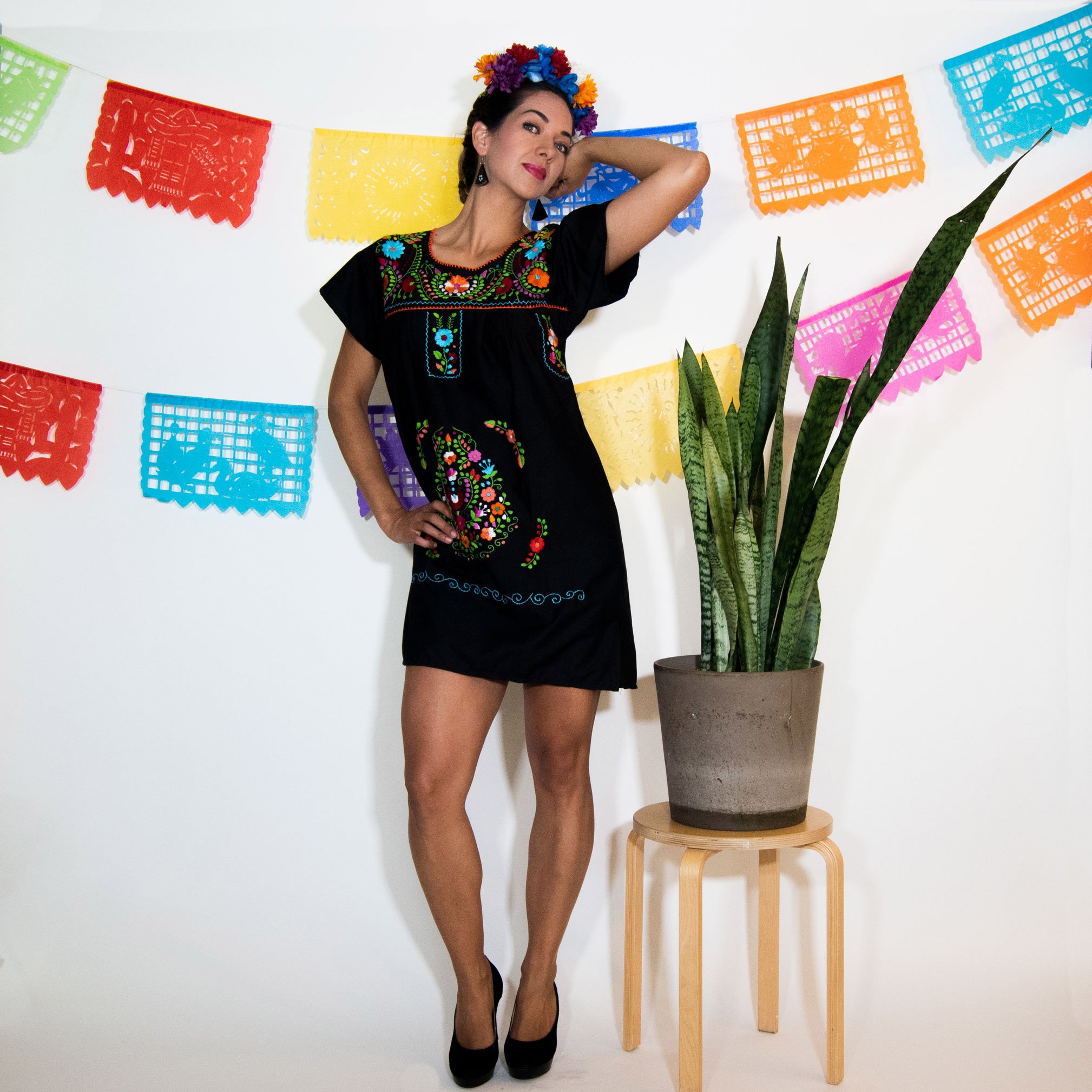 A beautiful Black Mexican Dress adorned with vibrant multicolored flowers, showcasing intricate hand embroidery.