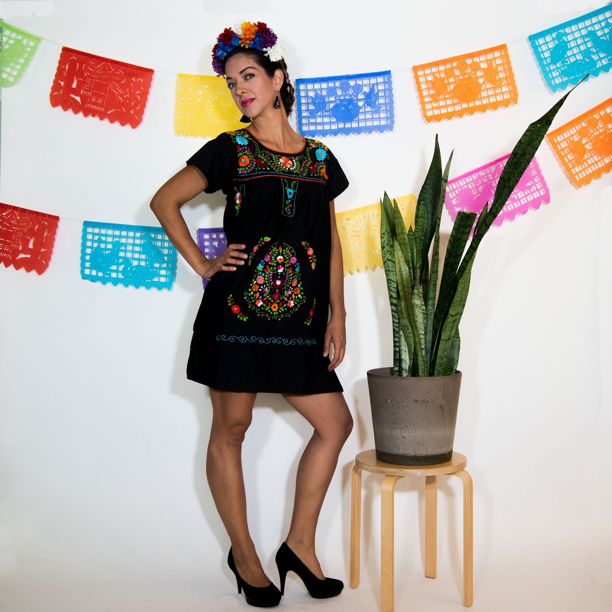 A beautiful Black Mexican Dress adorned with vibrant multicolored flowers, showcasing intricate hand embroidery.