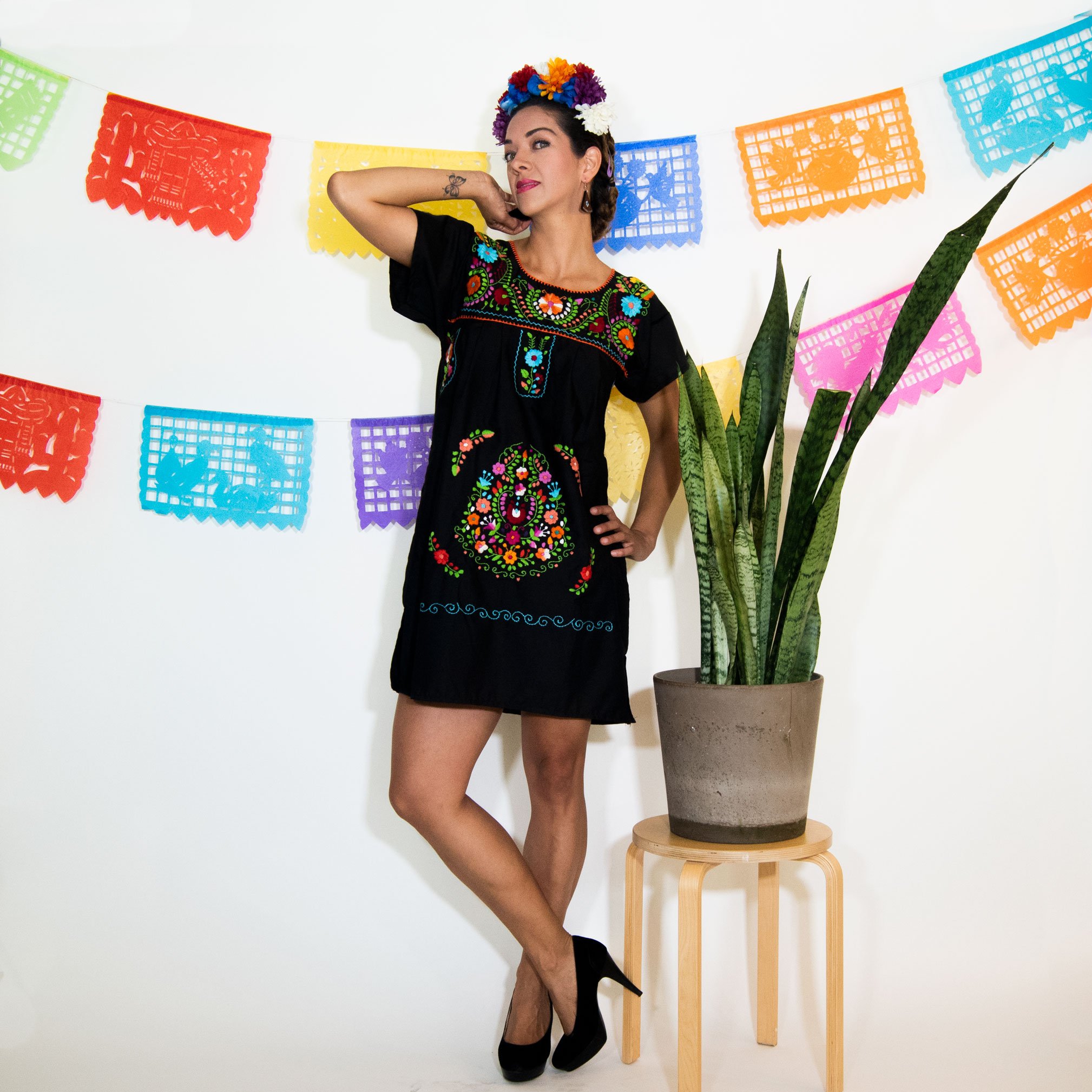 A beautiful Black Mexican Dress adorned with vibrant multicolored flowers, showcasing intricate hand embroidery.