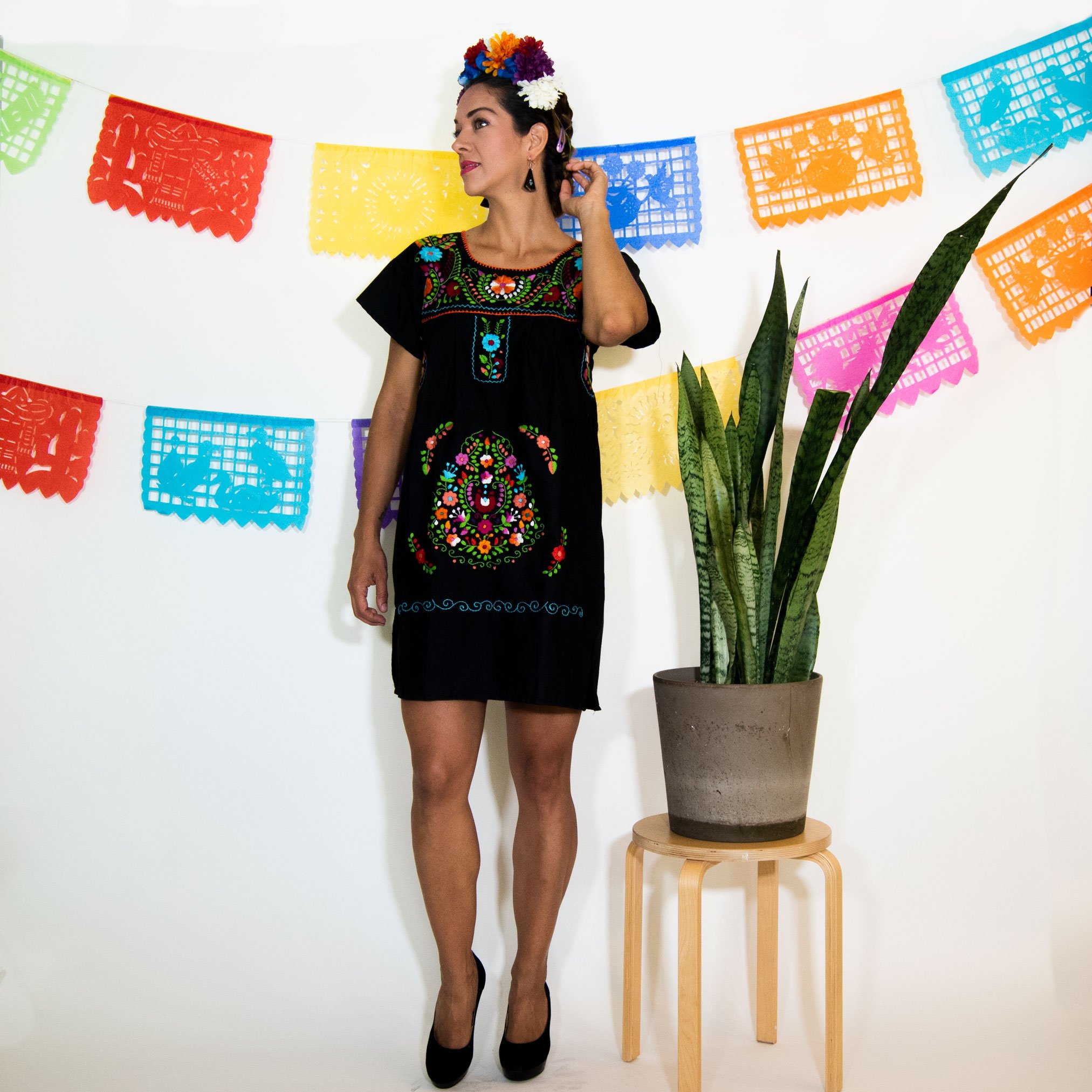 A beautiful Black Mexican Dress adorned with vibrant multicolored flowers, showcasing intricate hand embroidery.