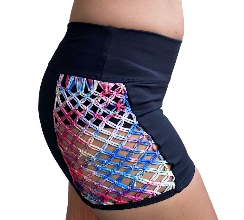 Black & Rainbow Macramé Athletic Shorts featuring mid-rise waistband and colorful macramé side cut-outs, perfect for workouts.