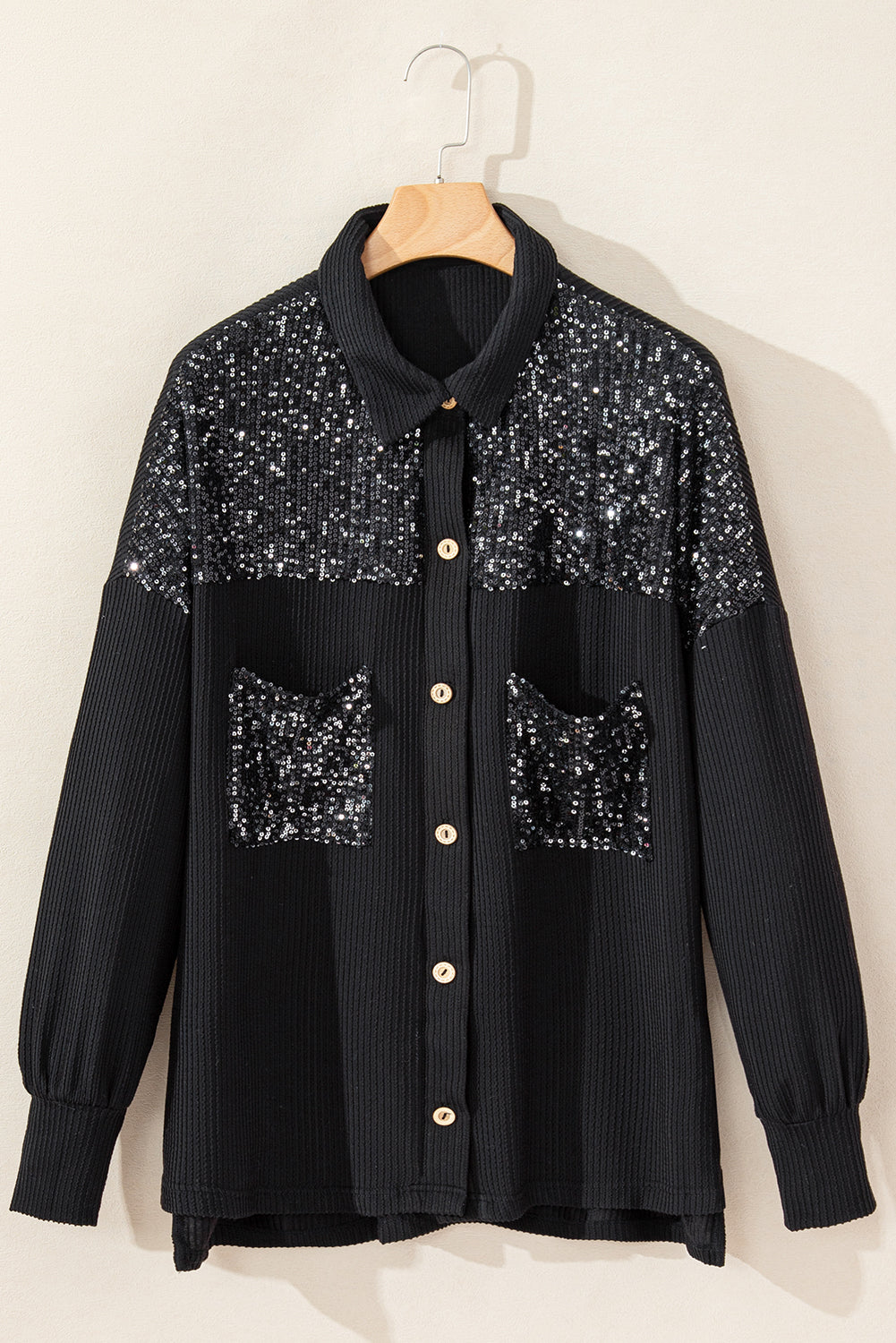 Black corded shacket featuring a sequin patch on the chest pocket, designed for casual wear with long sleeves.