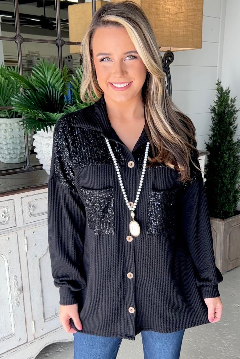 Black corded shacket featuring a sequin patch on the chest pocket, designed for casual wear with long sleeves.