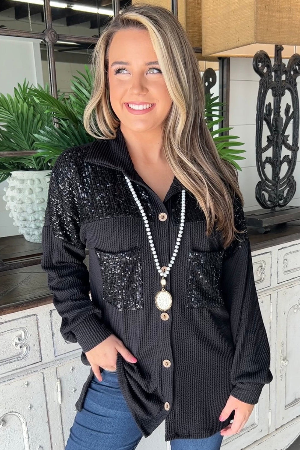 Black corded shacket featuring a sequin patch on the chest pocket, designed for casual wear with long sleeves.