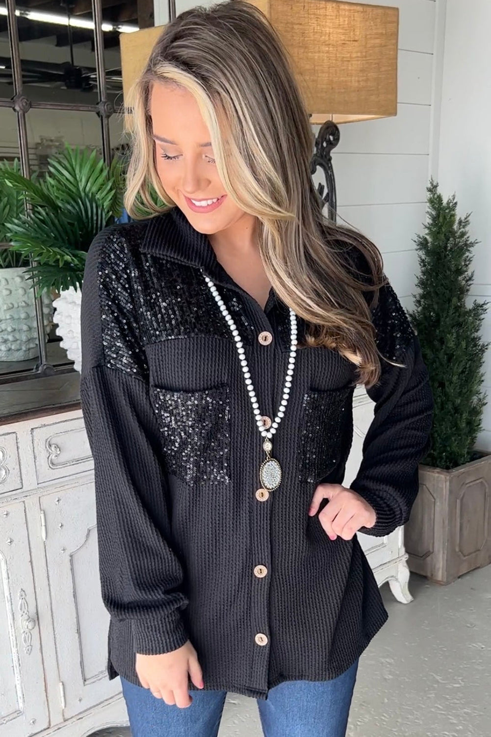 Black corded shacket featuring a sequin patch on the chest pocket, designed for casual wear with long sleeves.