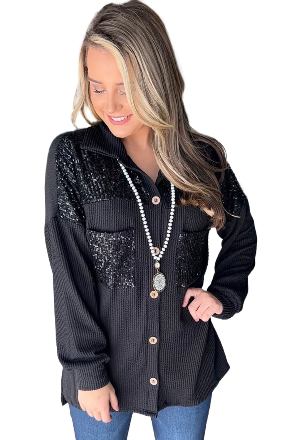 Black corded shacket featuring a sequin patch on the chest pocket, designed for casual wear with long sleeves.