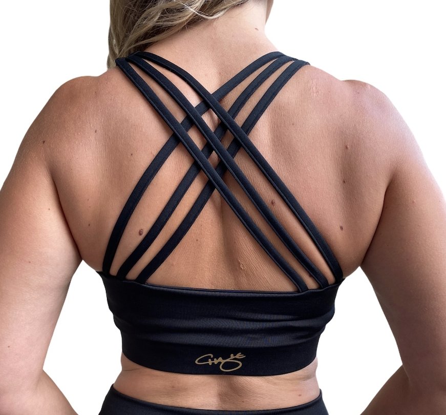 Black sports bra featuring fanned crossed back straps and scoop neck design, perfect for yoga and gym workouts.