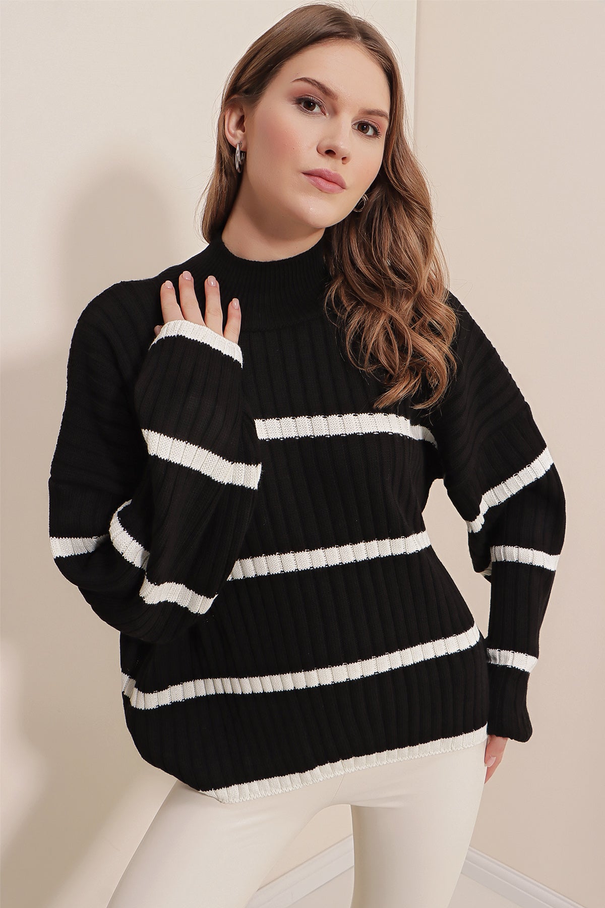 A stylish black striped sweater displayed on a mannequin, showcasing its trendy design and comfortable fit.