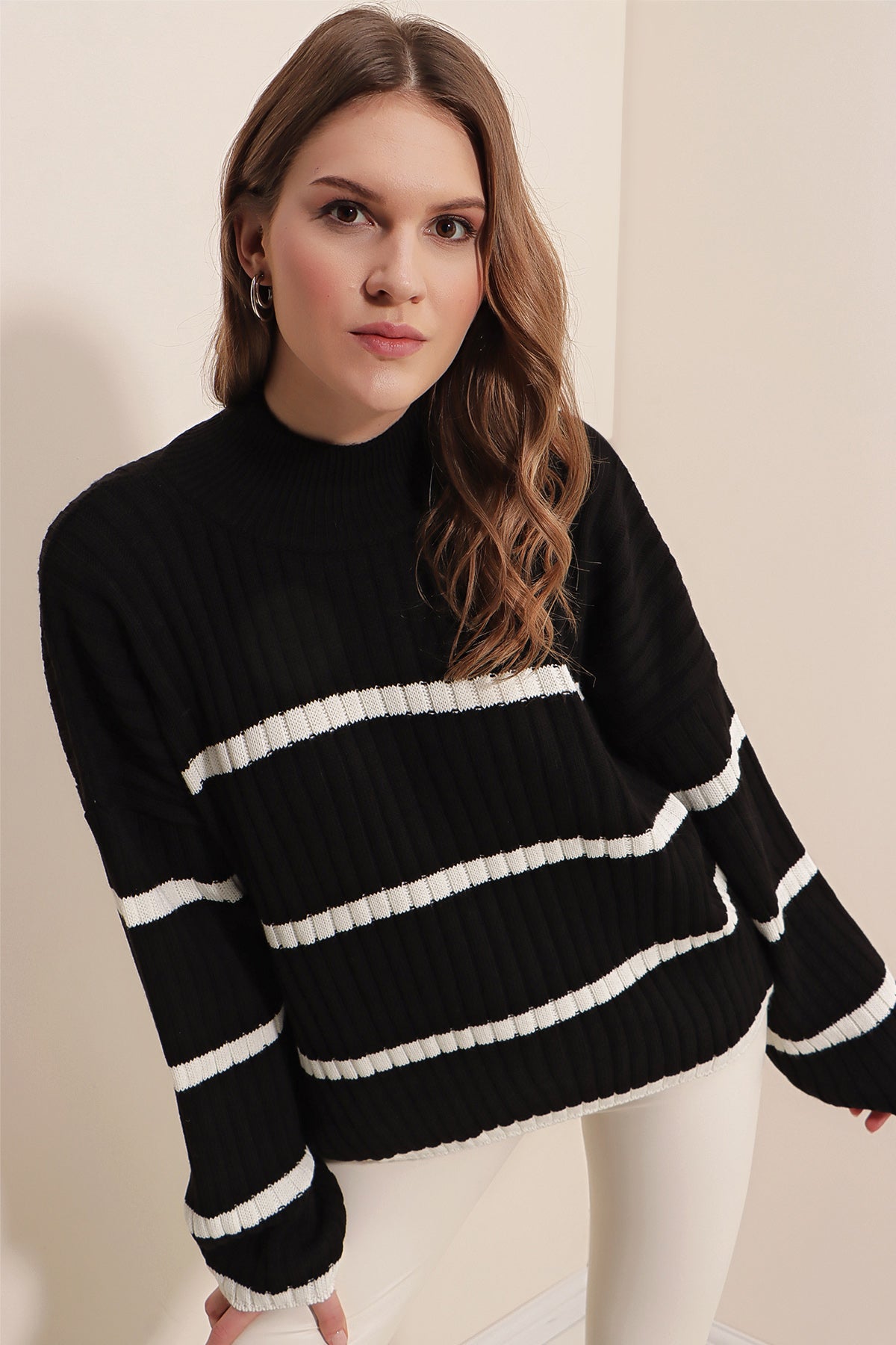 A stylish black striped sweater displayed on a mannequin, showcasing its trendy design and comfortable fit.