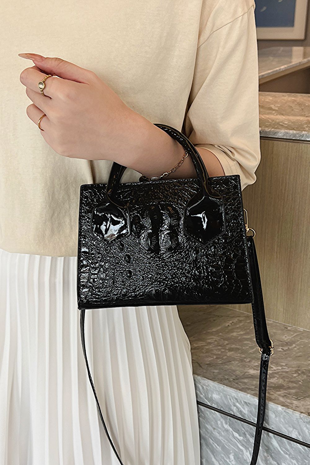 A stylish black textured crossbody bag made of PU leather, featuring a compact design and adjustable strap.