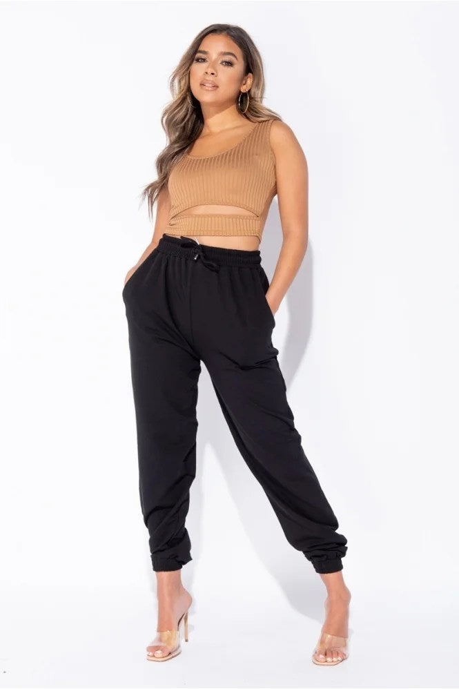 Black oversized joggers with a tie waist, featuring front pockets and a relaxed fit, perfect for casual wear.