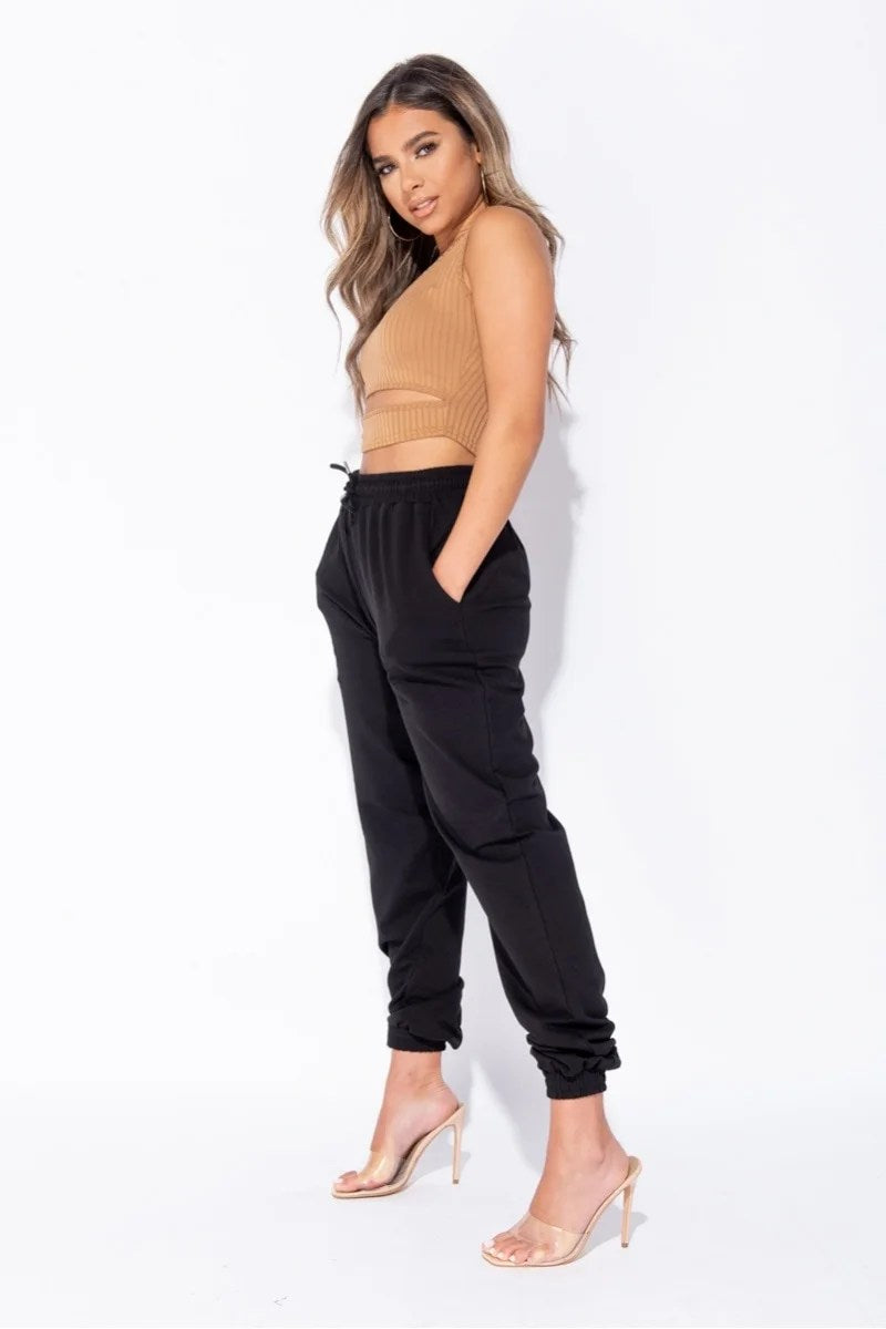 Black oversized joggers with a tie waist, featuring front pockets and a relaxed fit, perfect for casual wear.