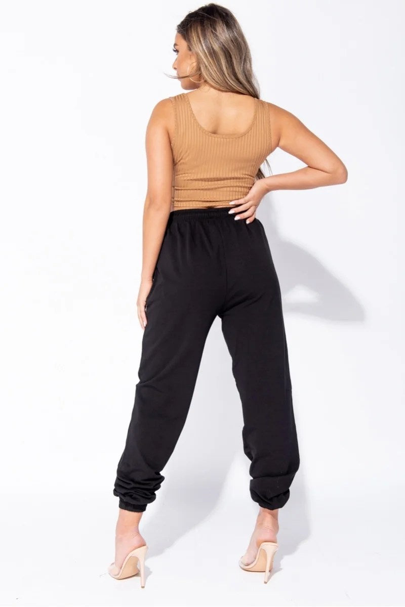 Black oversized joggers with a tie waist, featuring front pockets and a relaxed fit, perfect for casual wear.