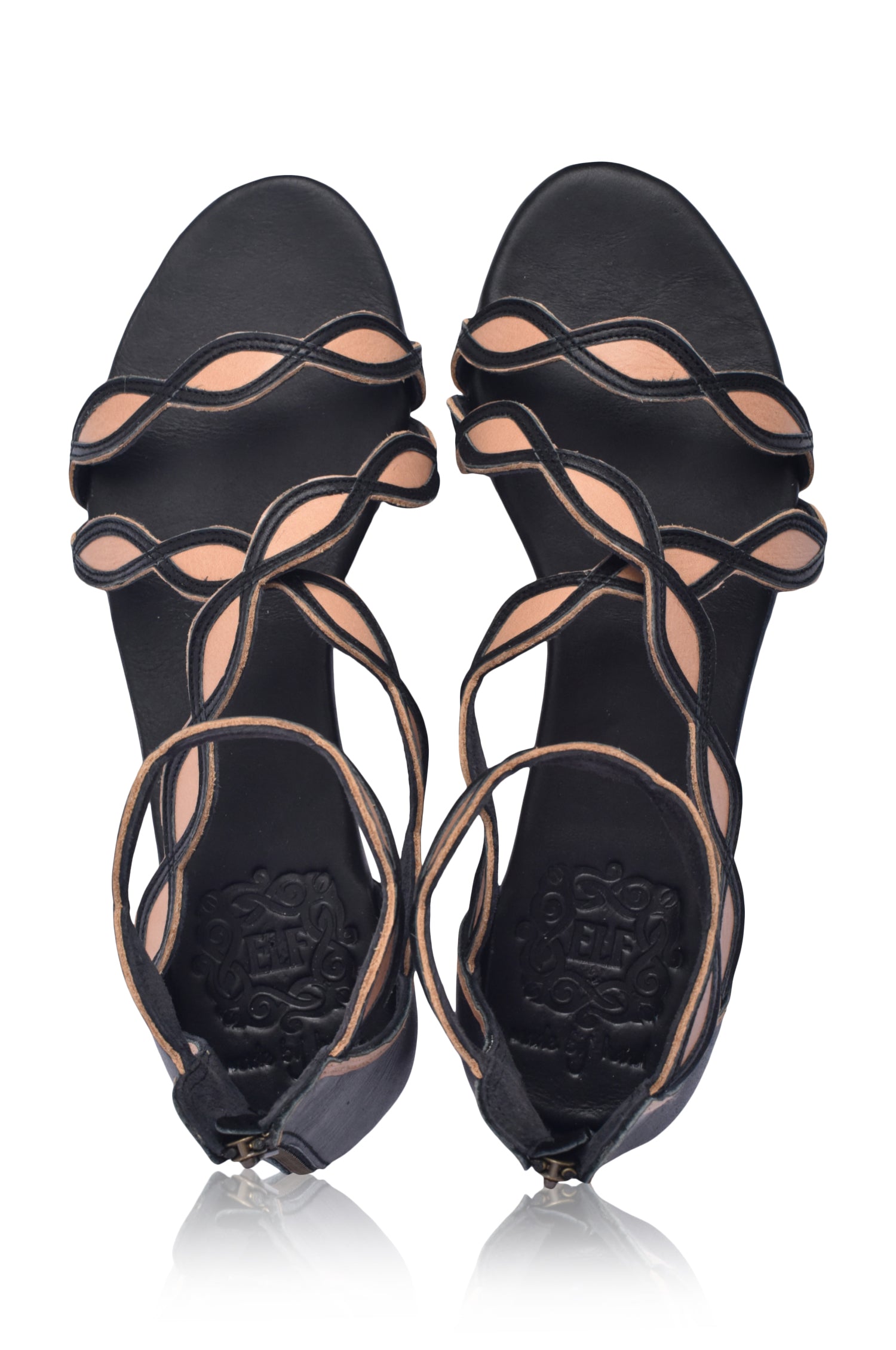 A pair of Blossom Leather Sandals featuring a floral design, handcrafted from high-quality leather with an adjustable ankle buckle and back zipper.