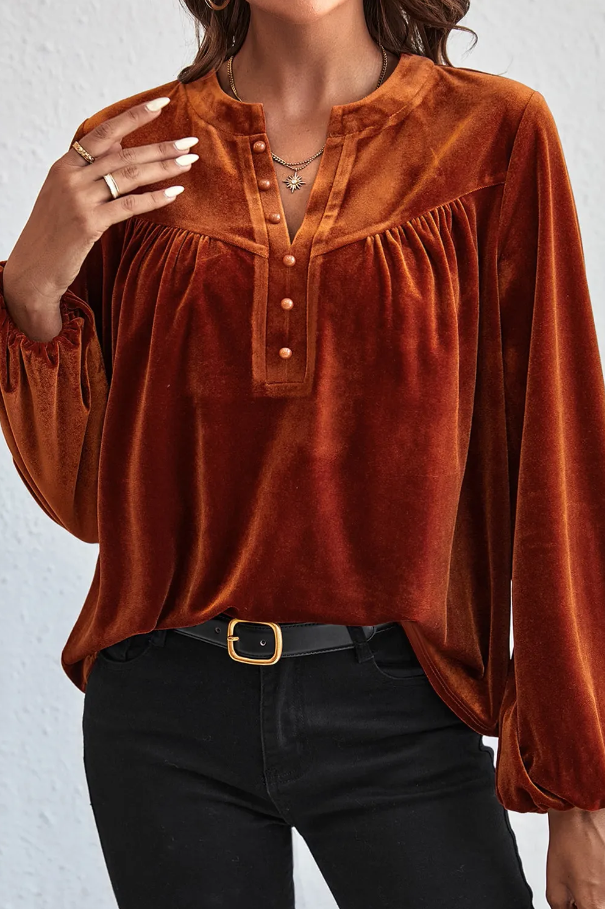 Elegant red blouse made of imitation velvet with a V neck and decorative buttons, featuring long sleeves and a loose fit.