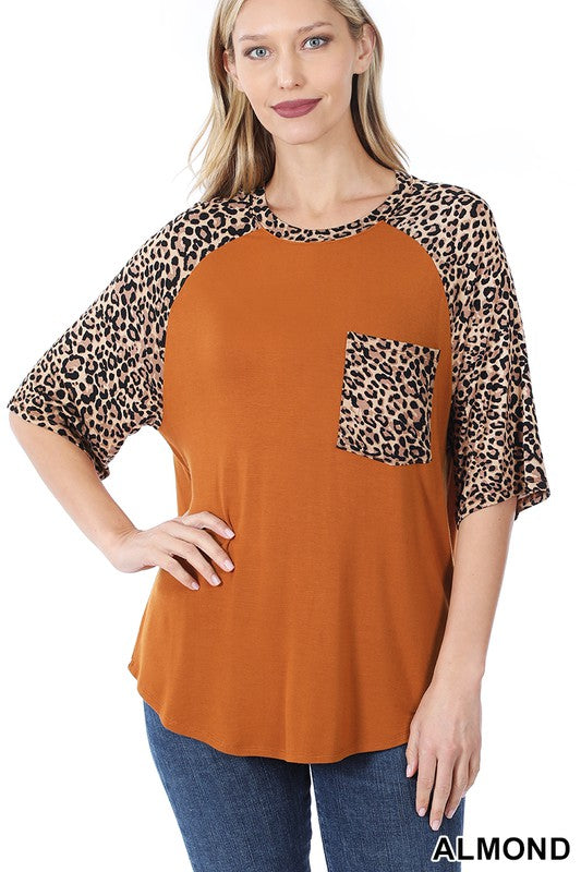 A stylish Bold Leopard Print Blouse featuring a relaxed fit, elbow-length sleeves, and a large chest pocket, with vibrant colors and leopard print details.